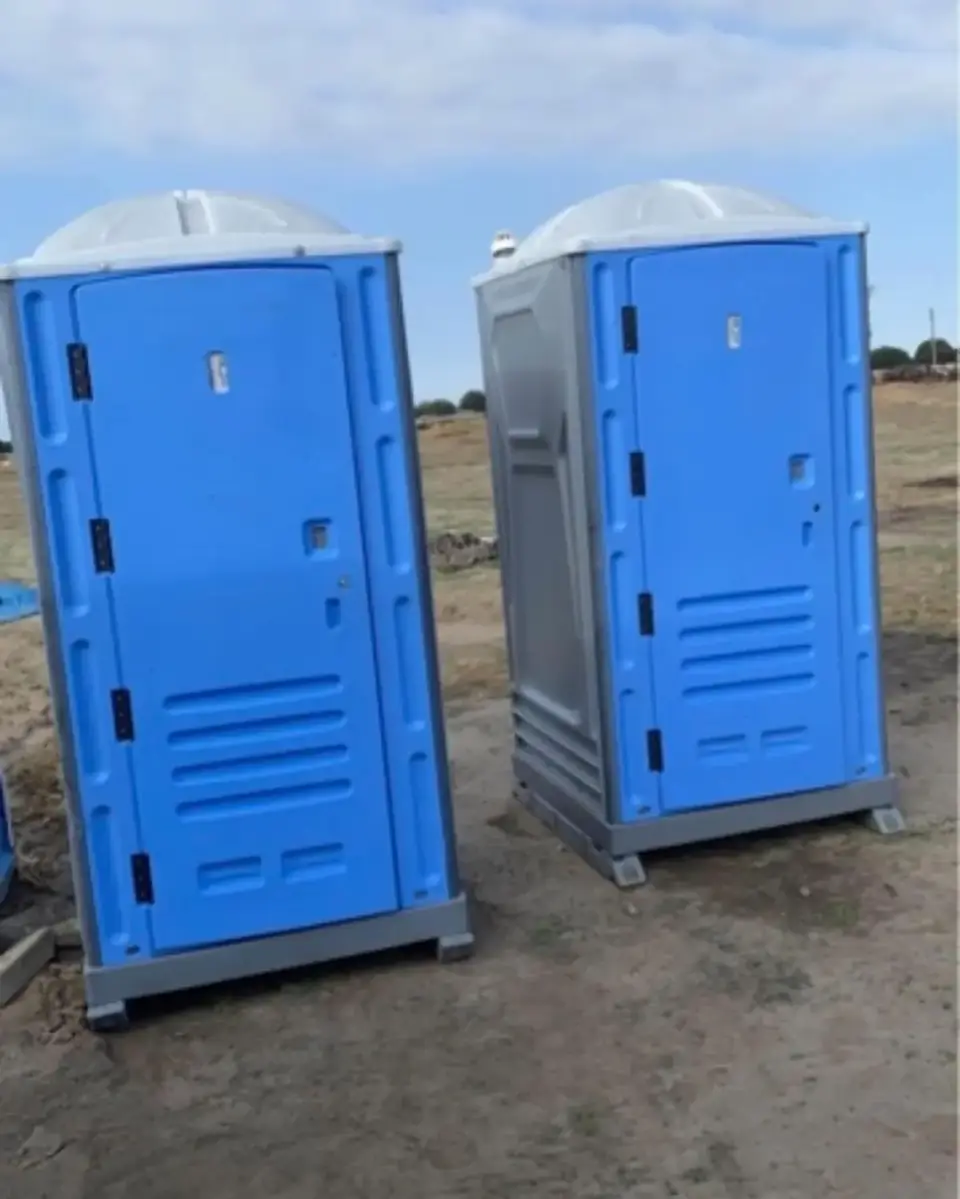 Blue standard porta potties set on a graded construction site